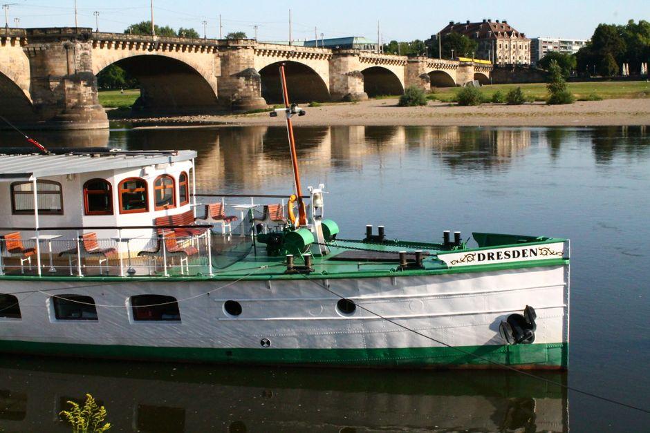 Ein Boot auf einem Fluß vor einer großen Brücke