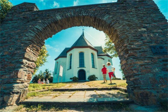 Rennende Kinder vor einer Kirche hinter einem Steintor