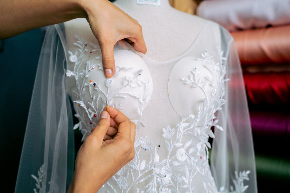 Bild von Anna Tarazevich auf Pexels: Schneiderin passt ein Brautkleid in einem Atelier an