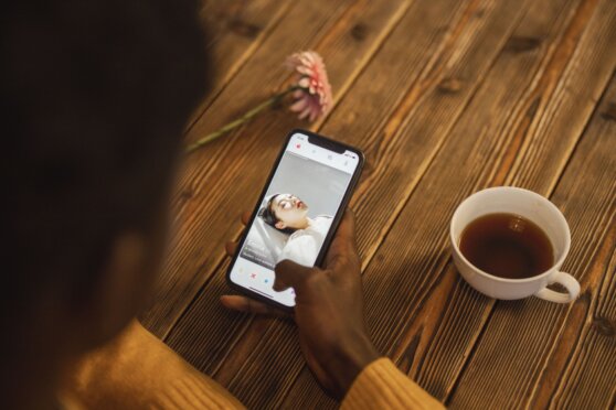 Person chattet lächelnd über eine Smartphone-App