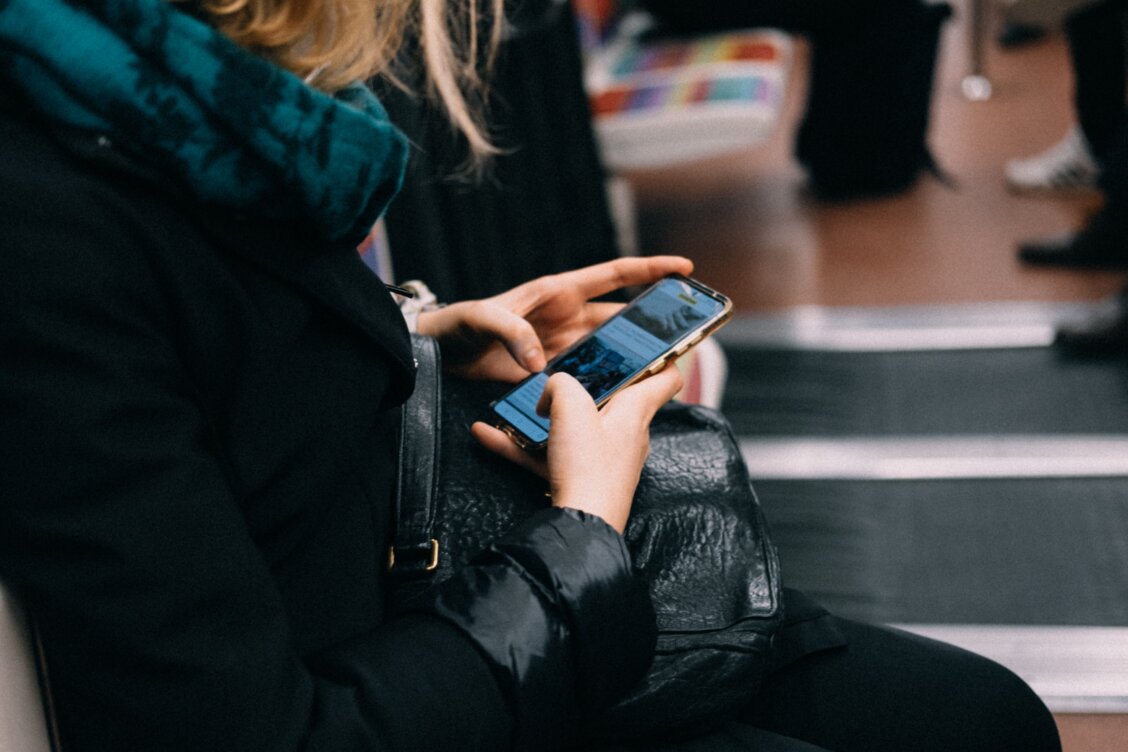 Frau nutzt sicher ihr Smartphone für Online-Banking unterwegs und vermeidet öffentliches WLAN