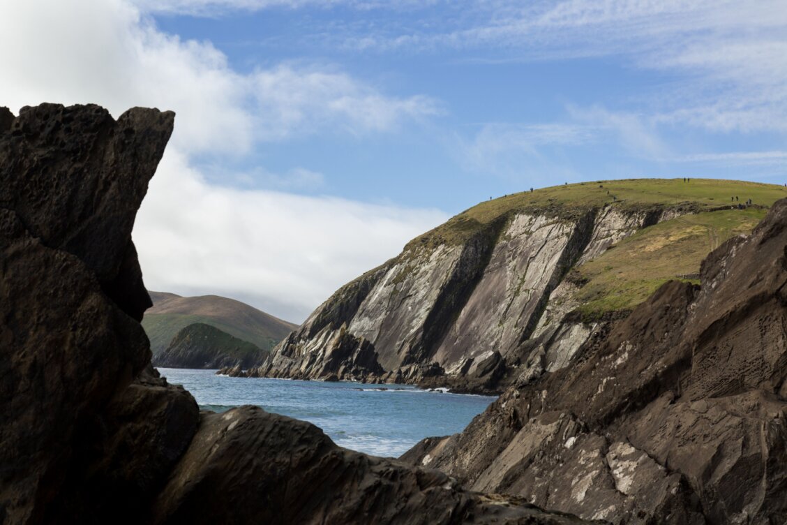 Bild von Michael Fischer auf Pexels: Wanderer auf einem Küstenpfad der Dingle-Halbinsel mit Blick auf den Atlantik