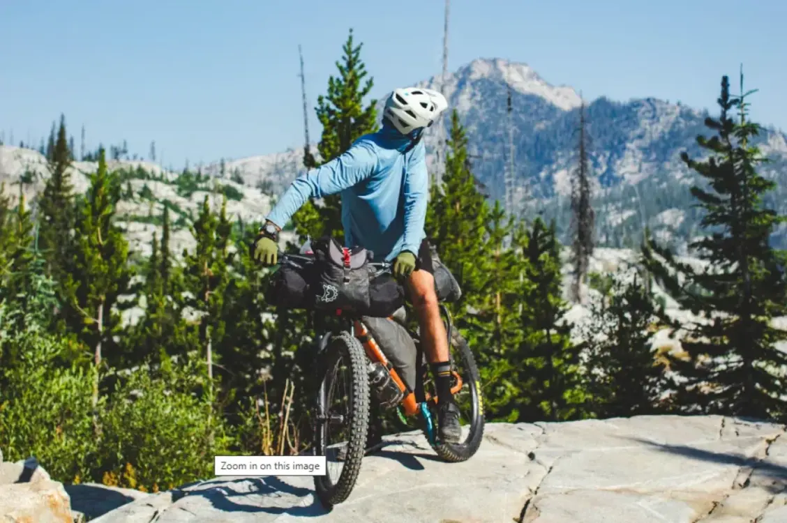 Mountainbiker auf einem Stein-Plateau vor einer herrlichen Bergkulisse