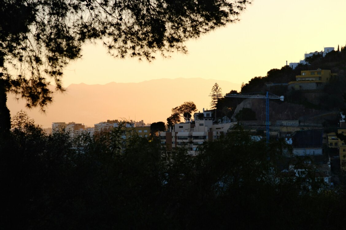 Bild von Raúl Mermans García auf unsplash: Der ferne Horizont der Stadt auf einem Hügel bei Sonnenuntergang
